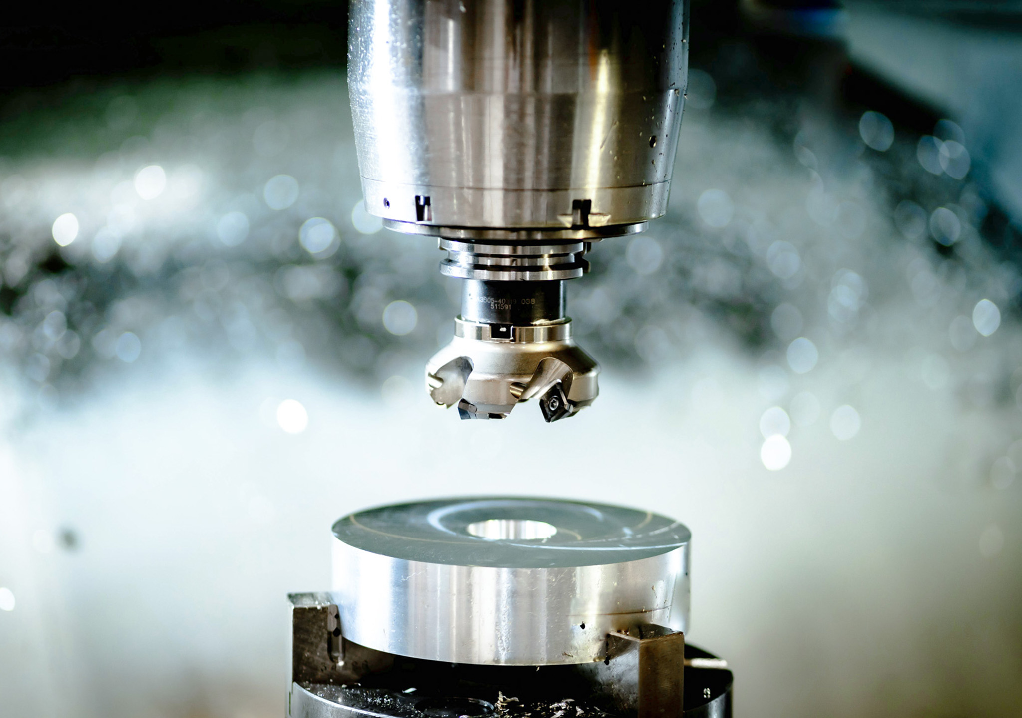 Fräskopf über einem eingespannten Metallwerkstück.